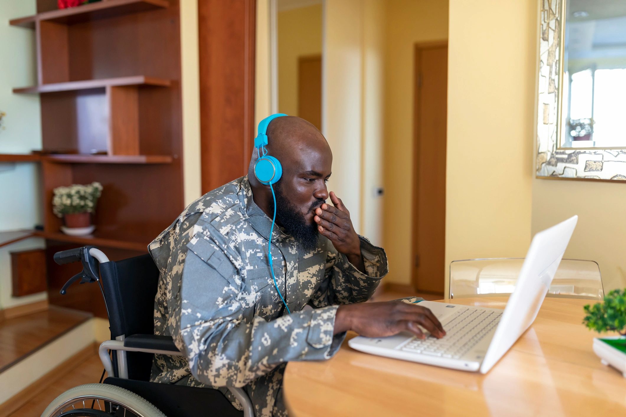 Veteran using a laptop with assistance in an office setting